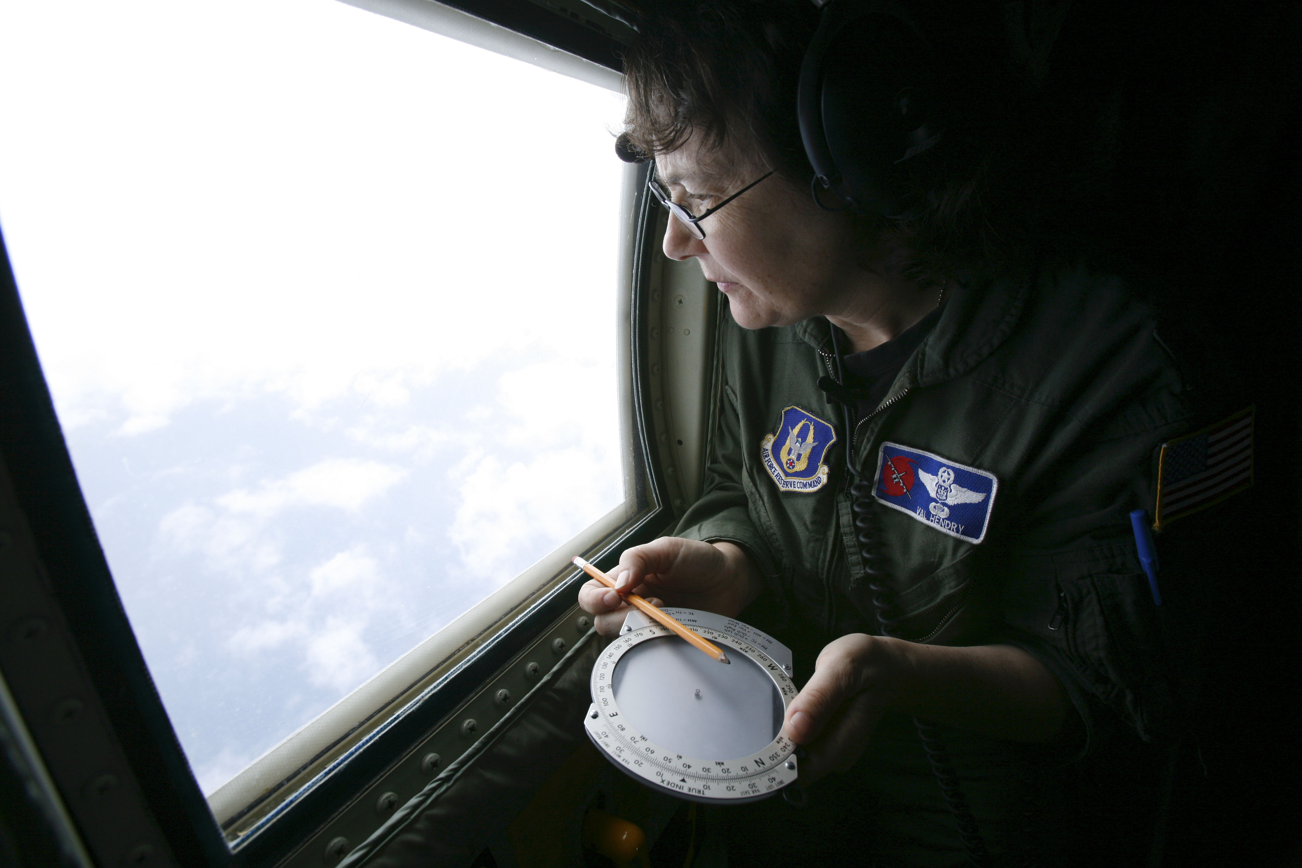 Weather officer Lt. Col. Valerie Hendry uses a rudimentary compass to gauge the direction of winds churning the ocean aboard a Hurricane Hunter plane above Tropical Storm Gustav in 2008. Weather officer Lt. Col. Valerie Hendry uses a rudimentary compass to gauge the direction of winds churning the ocean aboard a Hurricane Hunter plane above Tropical Storm Gustav in 2008.