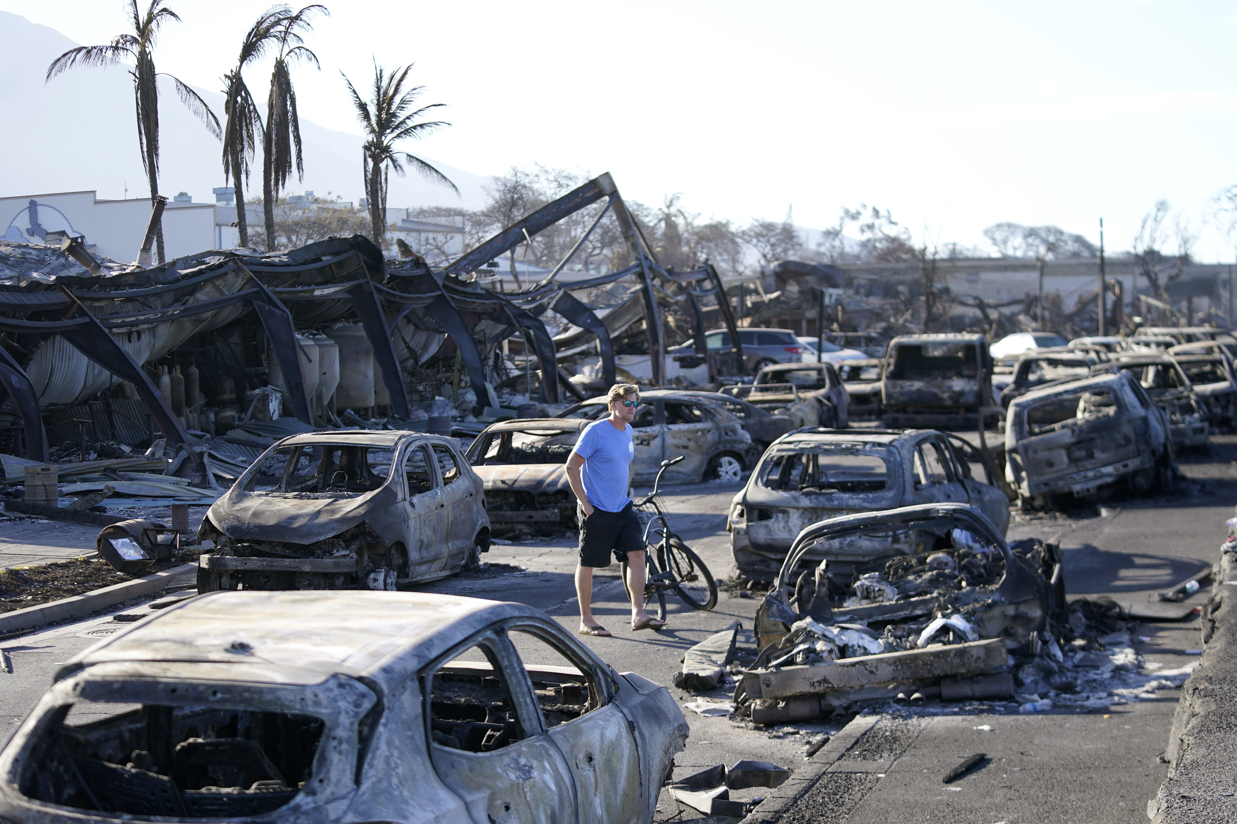 A man walks through wildfire wreckage in Lahaina. A man walks through wildfire wreckage in Lahaina.